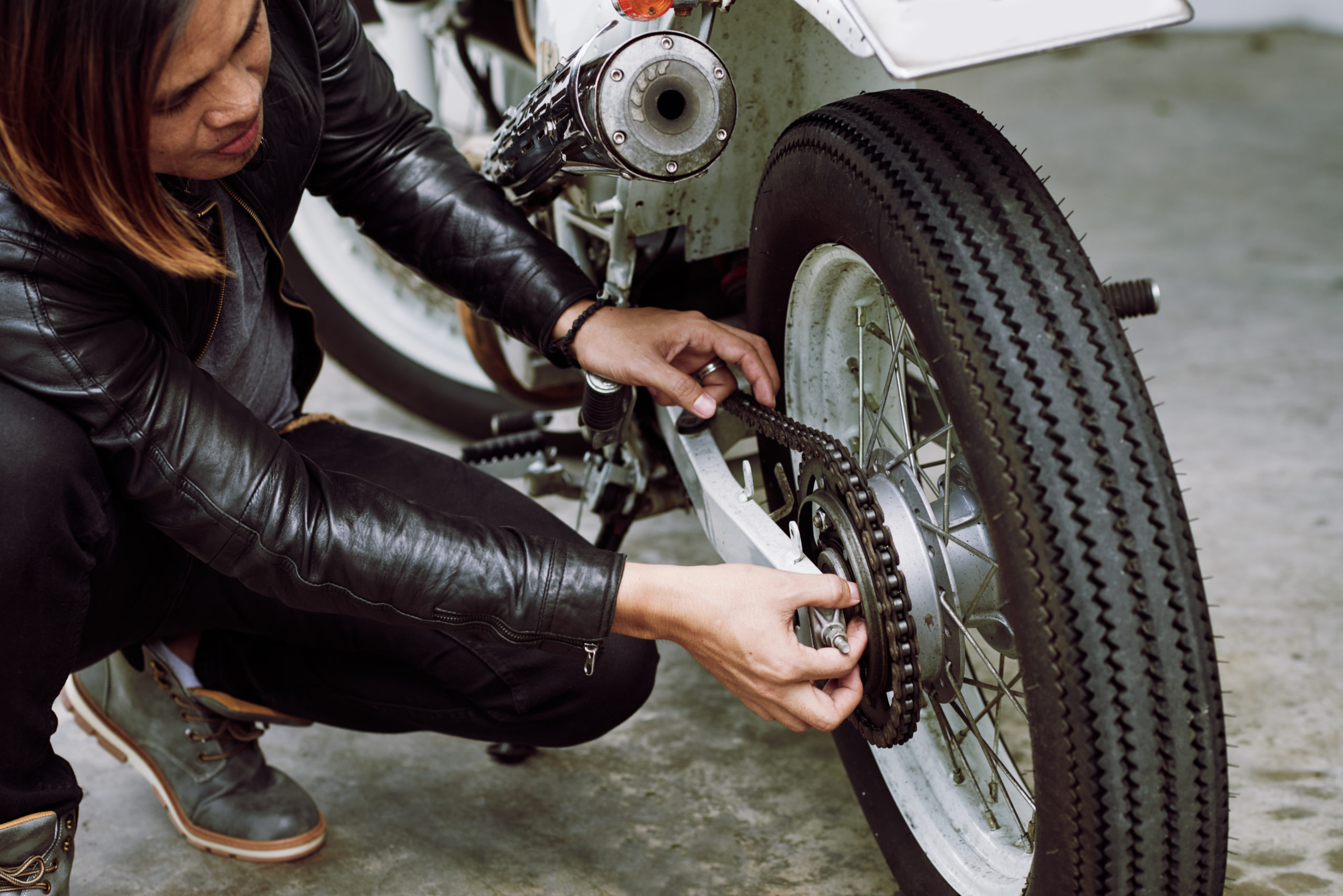 Мъж сменя износени гуми за мотор