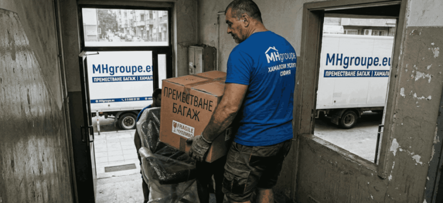 Професионален хамалин от MHgroupe внимателно пренася кашон по стълбище на кооперация, илюстрирайки сигурно пренасяне на багаж в София